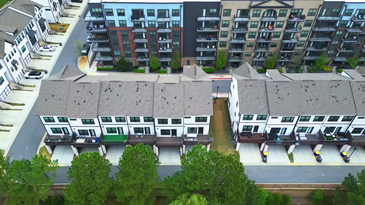 Row of townhouses and residential apartment buildings in american town. Aerial top down shot. Green trees on street in spring. Quiet american neighborhood in Georgia.