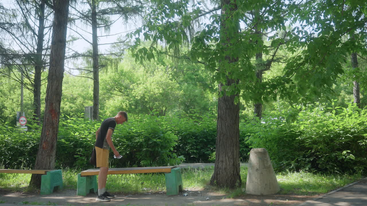 Young Man Carefully Inspects Park, Young Person Examines Park Bench Crevices Thoroughly, An Energetic Young Individual Diligently Investigates Small Spaces And Details Of Park Bench Area