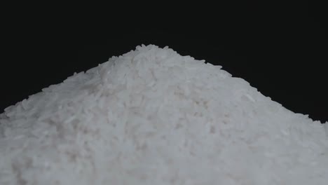 pile of white rice grain rotating in a slow motion, on a background
