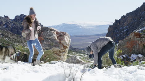 una pareja joven teniendo una pelea de bolas de nieve