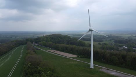 Disparo-De-Un-Dron-Capturando-Una-Turbina-Eólica-En-Un-Campo-Verde-En-Inglaterra