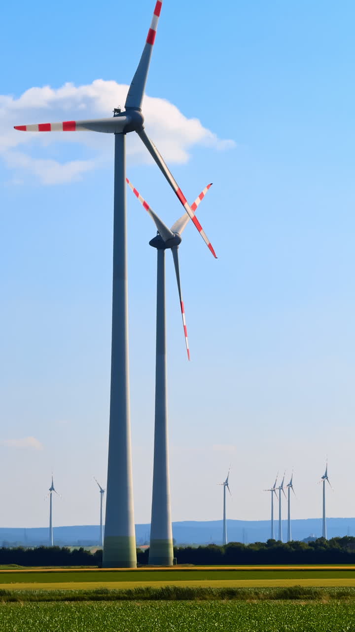 Turbines create farm energy. Large wind turbines stand tall against a clear blue sky, harnessing wind energy in a rural landscape during daylight