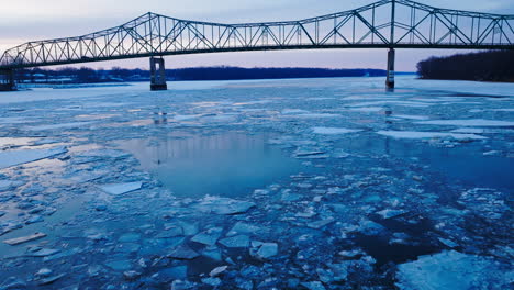 Drone-video-flying-over-chunks-of-ice-with-bridge-in-view