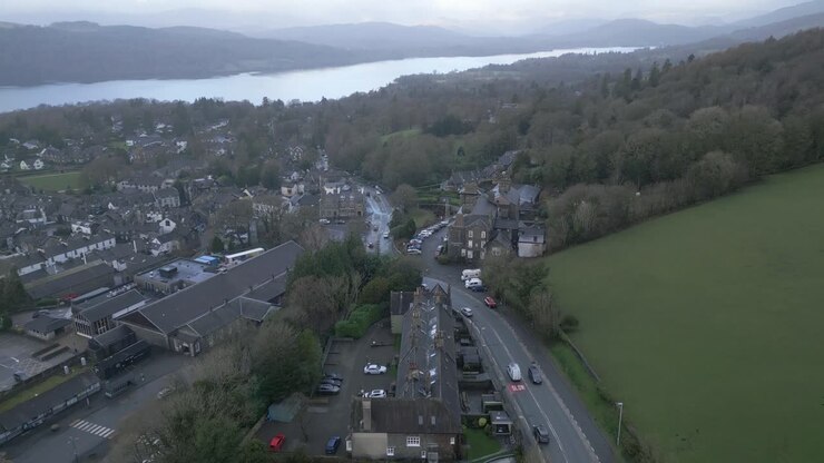 Drone che vola sopra la città di Windermere con il Lago Windermere in lontananza.