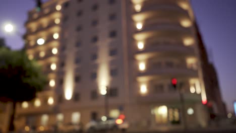 city at night with cars passing by at rush hour in out of focus