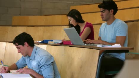 estudiantes sentados uno al lado del otro mientras aprenden