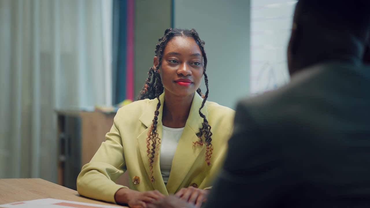Happy confident black woman recruit handshaking employer getting hired at new job. Smiling young female professional manager shake hand of black man client or customer making business office meeting