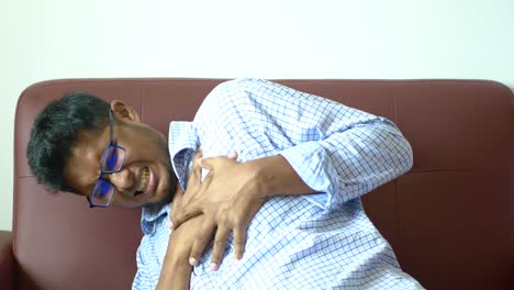 young man suffering pain in heart and holding chest with hand