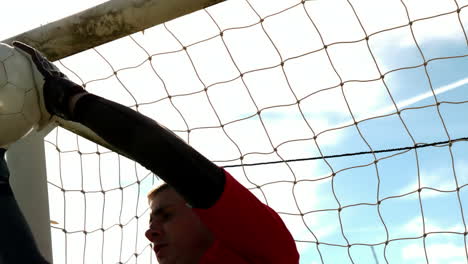 goalkeeper in red making a save