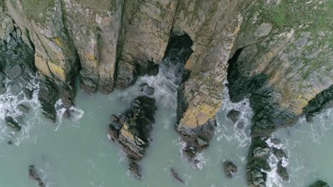 aerial top down tracking inland over a strange formation of rocks that form an unusual cliff