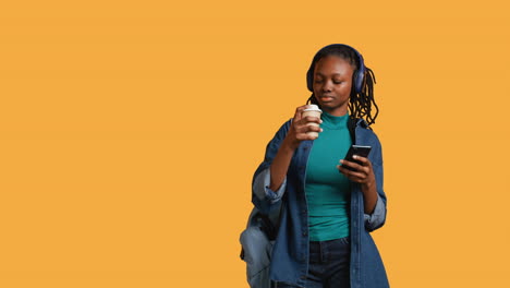 Woman-scrolling-on-smartphone,-drinking-coffee,-studio-background