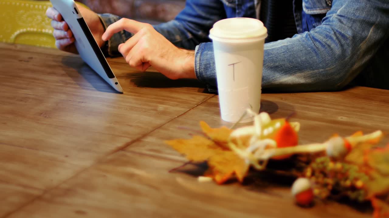 hombre usando tableta digital mientras toma café