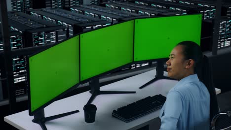 side view of asian woman having backache while working with mock up multiple computer monitor in data center