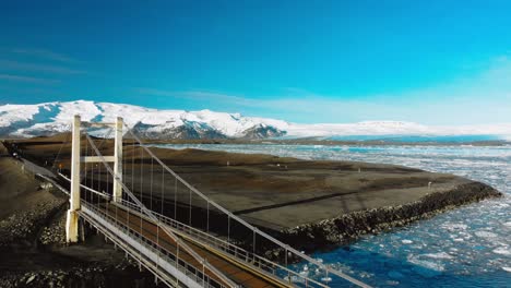 icelandic bridge flyover with glacier backdrop
