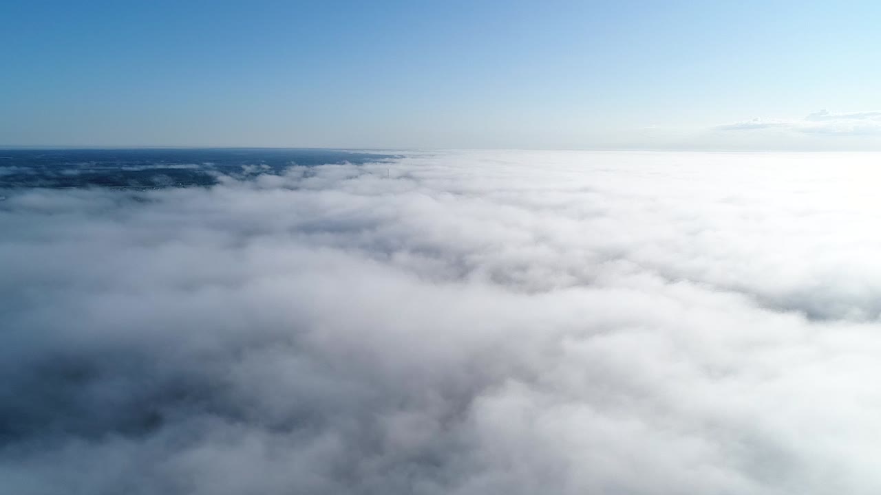Flight over misty clouds in morning sunlight with little glory and city scape under clouds