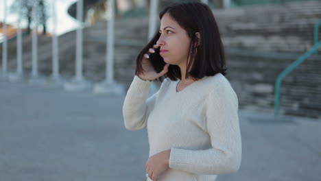 Beautiful-young-woman-with-braces-talking-on-smartphone-outdoor