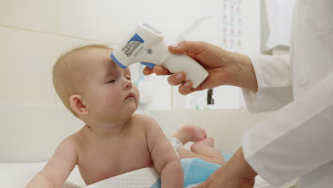 doctor checking baby's temperature