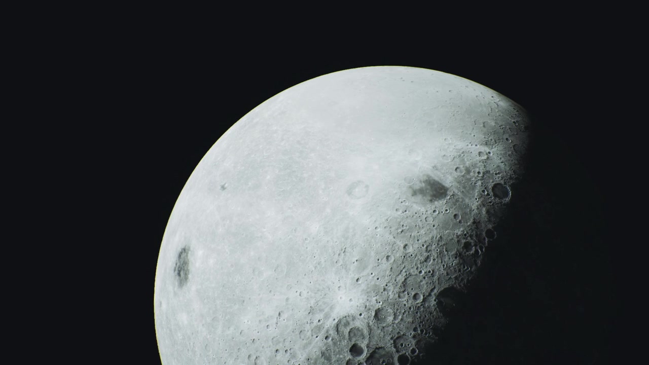 A superfície serena da lua brilha intensamente contra o céu noturno escuro.