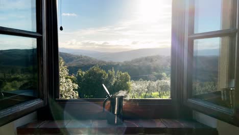 steaming hot coffee in a espresso maker on a window sill in the morning with a beautiful landscape in the background