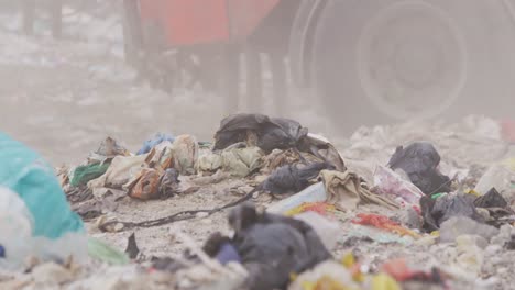 vehículos que limpian la basura apilada en un vertedero lleno de basura