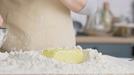 close up video of falling block of butter into flour