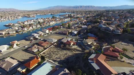 aerial over a suburban neighborhood in the desert with an artificial lake distant