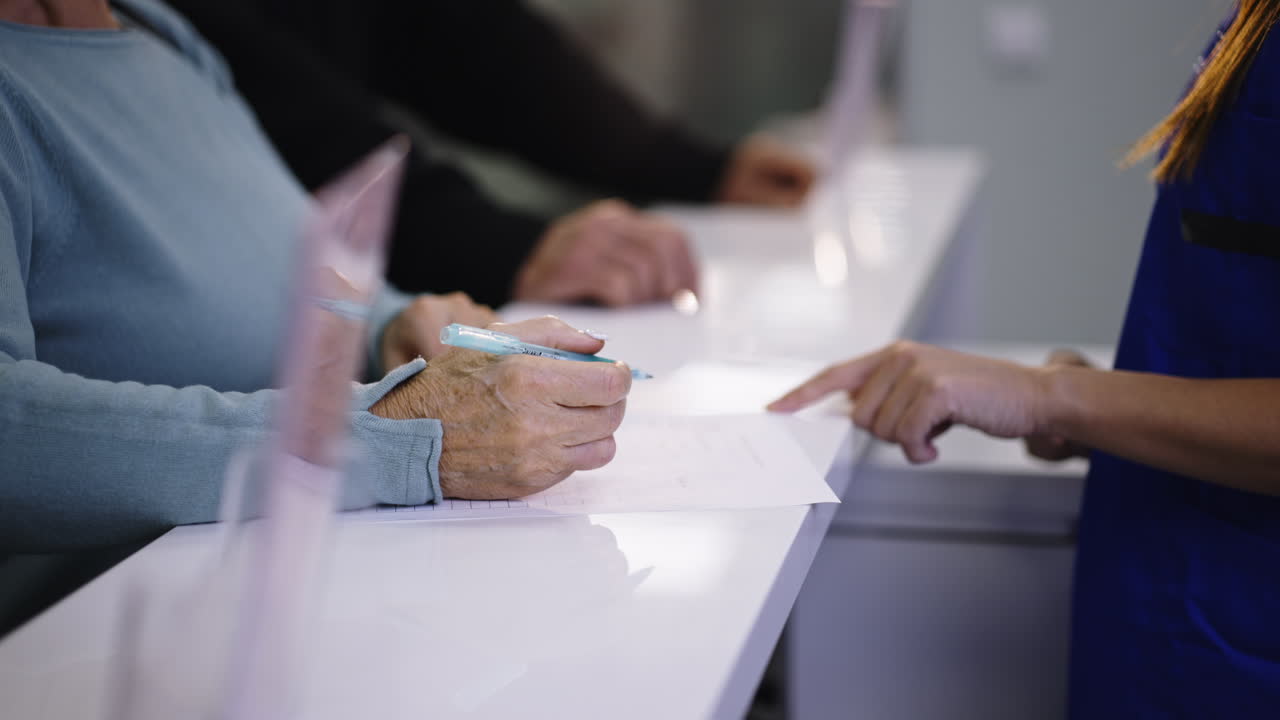 Patient signing form at reception desk