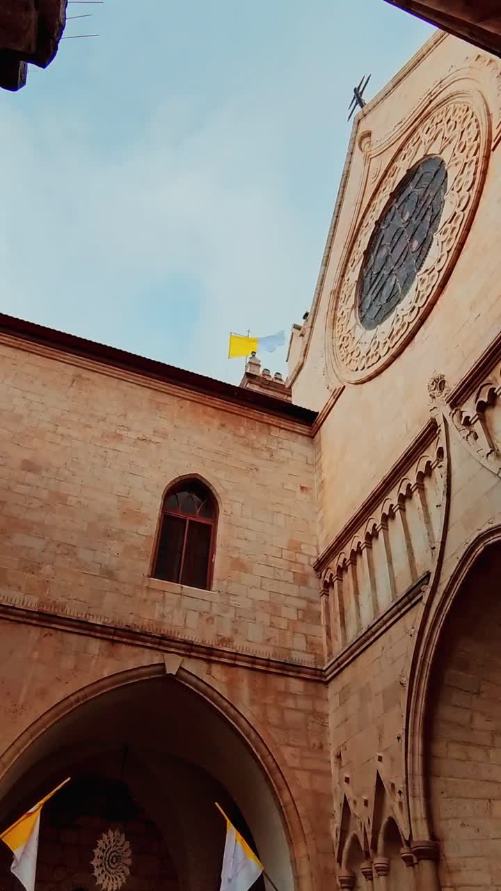 Chiesa storica con rosone e bandiere del Vaticano a Gerusalemme
