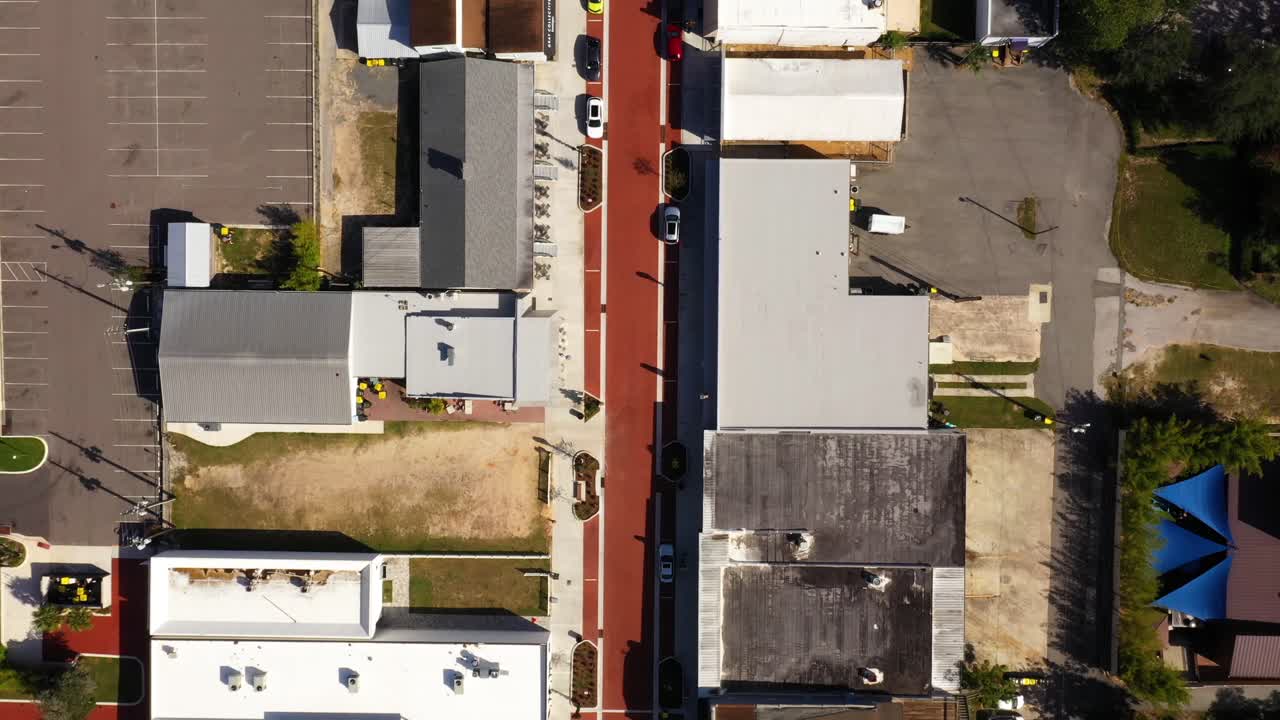 Drone top down bird's eye view of historic main street road and buildings at midday