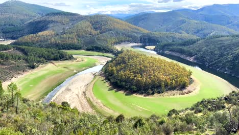 Colorido-Meandro-Natural-Donde-El-Río-Fluye-Dejando-Un-Islote-Arbolado-En-Un-Gran-Valle-Verde