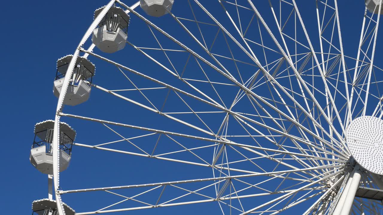 колесо обозрения в действии против голубого неба.
