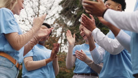 un grupo diverso de voluntarios aplaudiendo y celebrando su éxito juntos