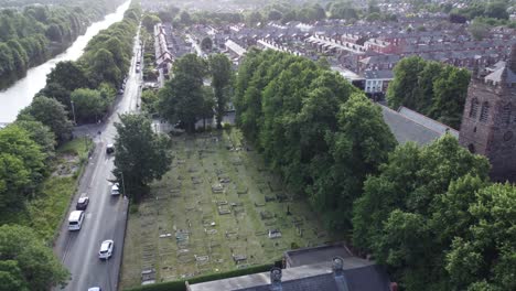 vista aérea escénica por encima de la pintoresca campiña aldea iglesia cementerio y canal vía navegable órbita tiro izquierdo