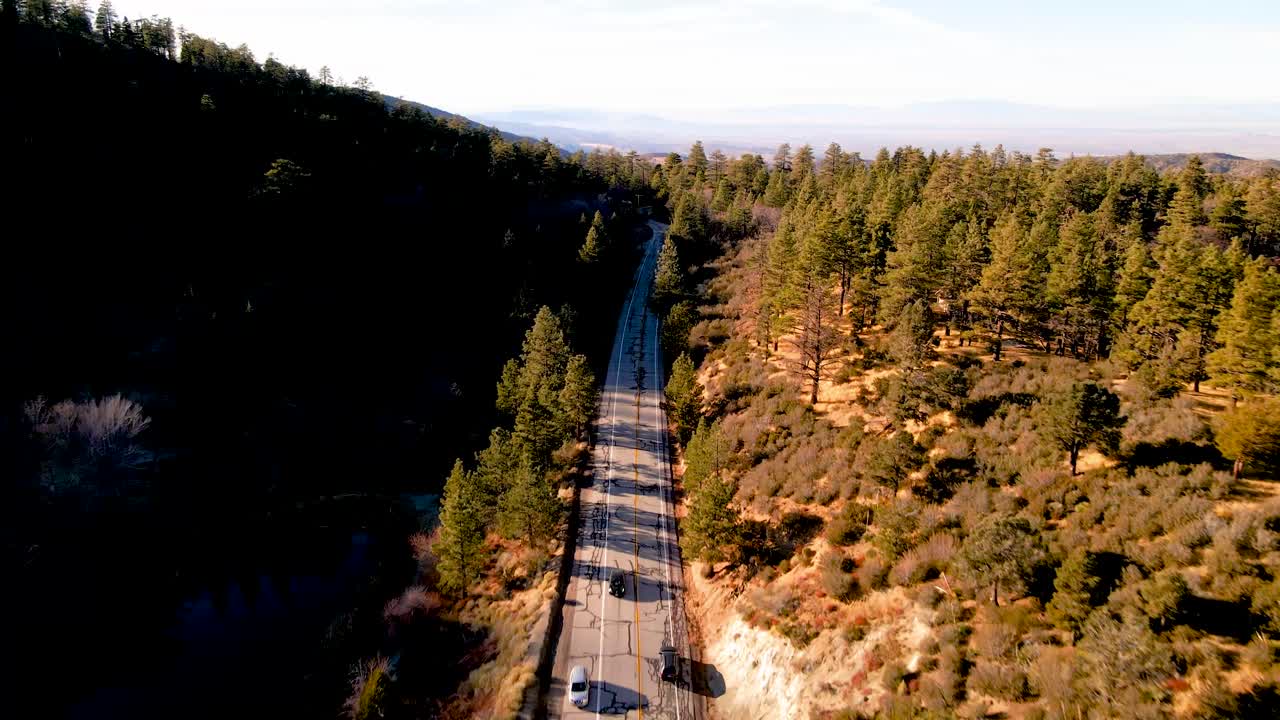 coches conduciendo por una carretera de montaña junto al lago