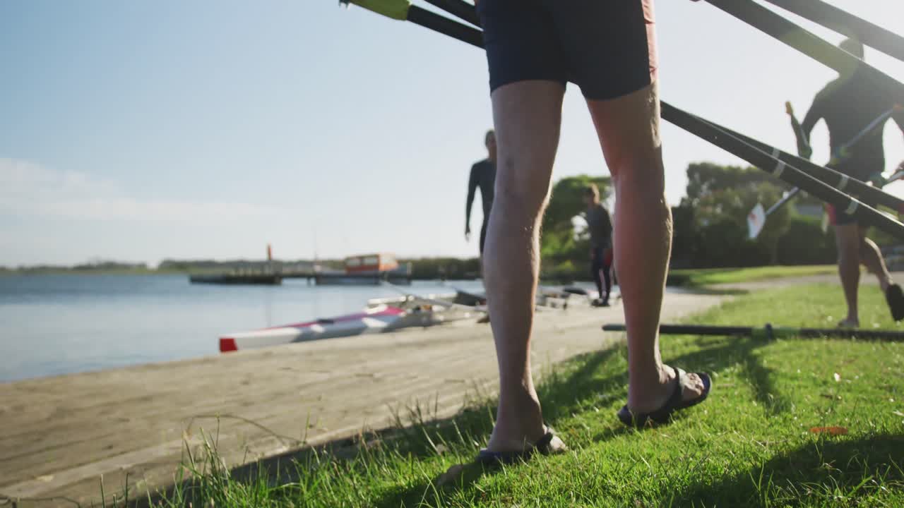 Four senior caucasian men and women preparing rowing boat in a river
