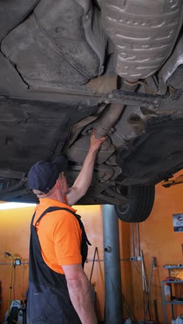 mechanic inspecting the underside of a car on a lift