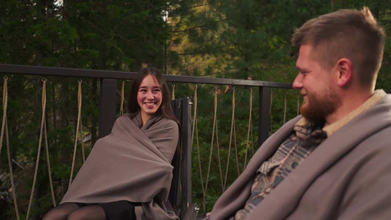 한 커플 이 가을 의 verandah 에 편안 하게 앉아 있다