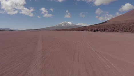 rising aerial across atacama desert toward licancabur volcano in chile