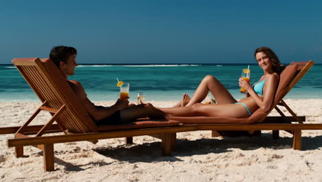 couple relaxing on a tropical beach with drinks