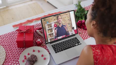 Diverse-couple-on-a-valentines-date-video-call-man-talking-on-laptop-screen