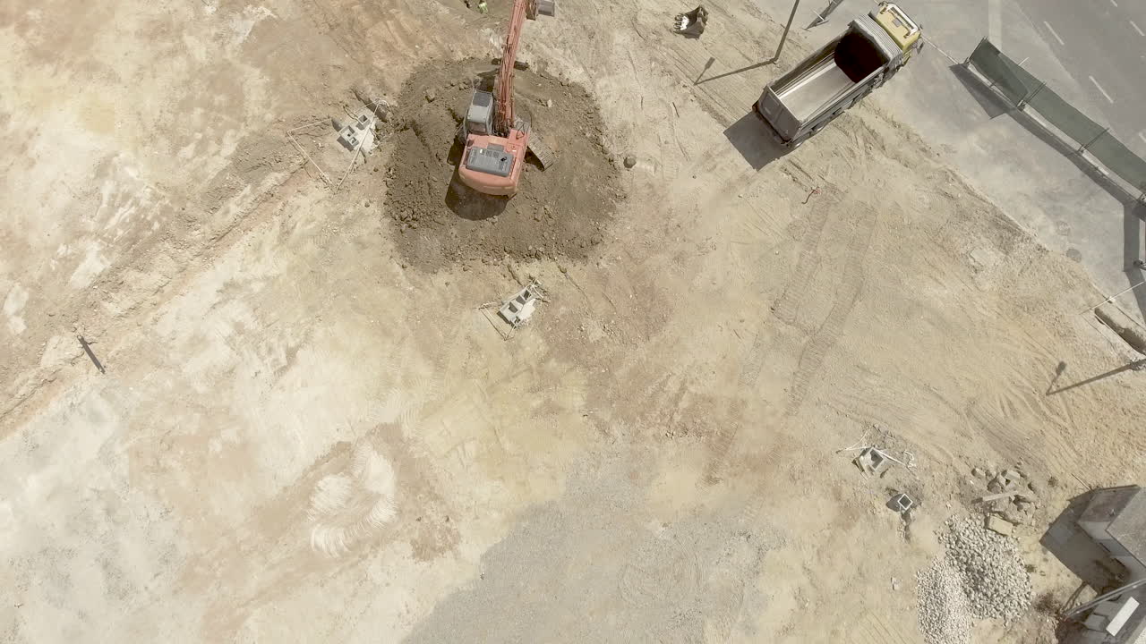 retroexcavadora en el trabajo - excavación de suelo excavado en el sitio de construcción - tiro de dron de retroceso