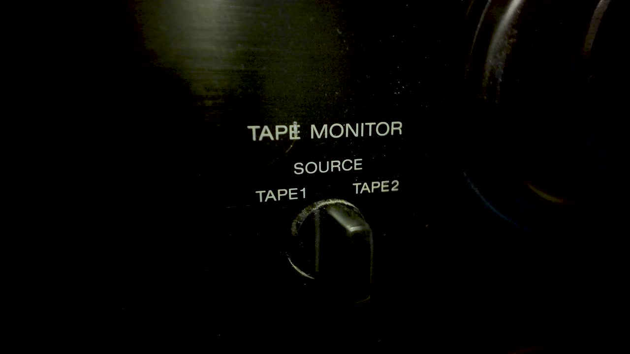 Close-up of a finger turning the tape monitor source switch on a vintage hi-fi system
