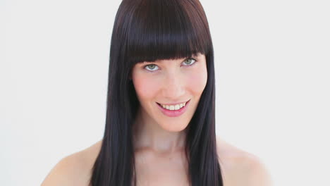 una mujer sonriente peinándose el cabello.