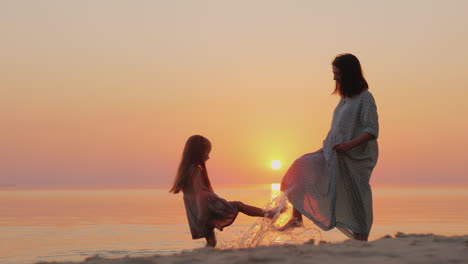 a pregnant mother plays with her daughter for six years by the water happy and have fun togetherr wa