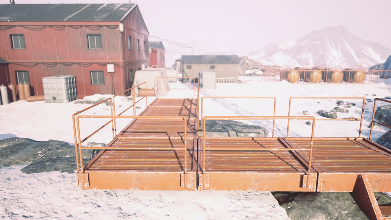 снежный ландшафт с металлической дорожкой, соединяющей здания в отдаленном районе