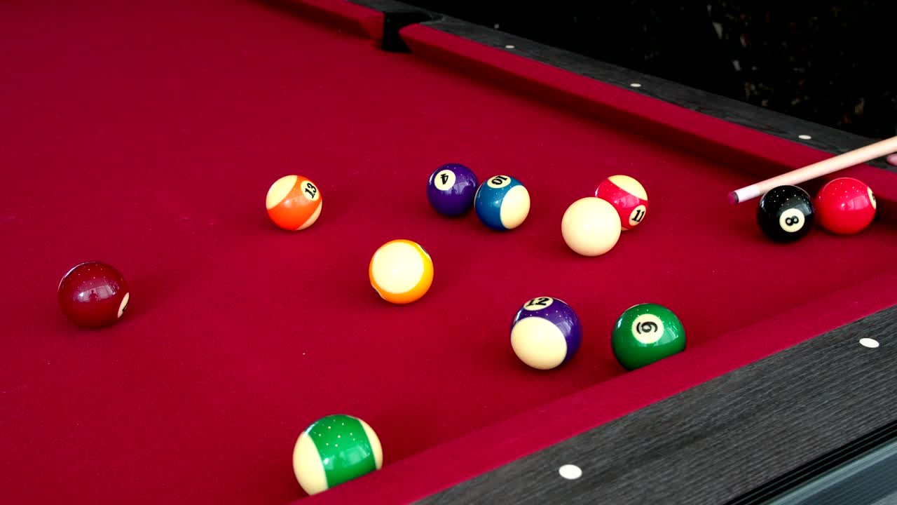 jugando al billar en la mesa roja. esto es deporte.