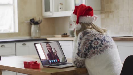 Mujer-Caucásica-Con-Sombrero-De-Papá-Noel-Usando-Una-Computadora-Portátil-En-Un-Video-Chat-Durante-La-Navidad-En-Casa