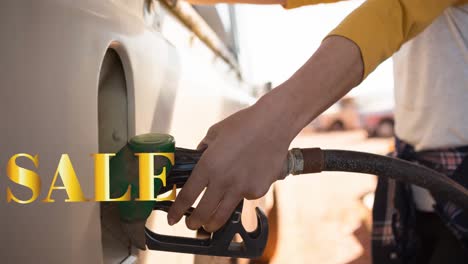 Animation-of-sale-text-in-gold-over-midsection-of-woman-using-fuel-pump-at-petrol-station