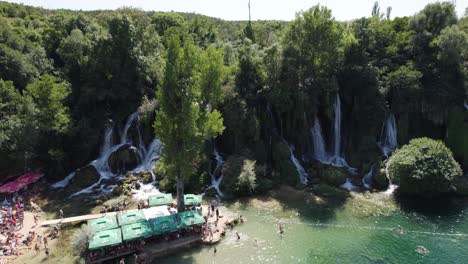 summer day at kravica waterfall with tourists, bosnia