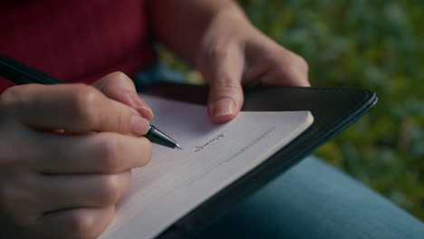 mujer escribiendo en un cuaderno al aire libre